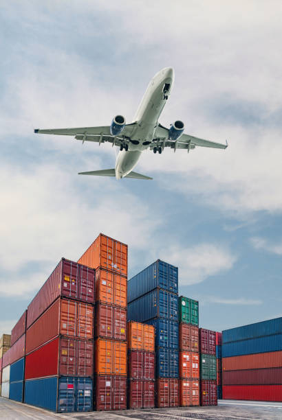 Airplane flying above container port. Cargo and shipping business in a commercial port. Container ship for import and export logistic.